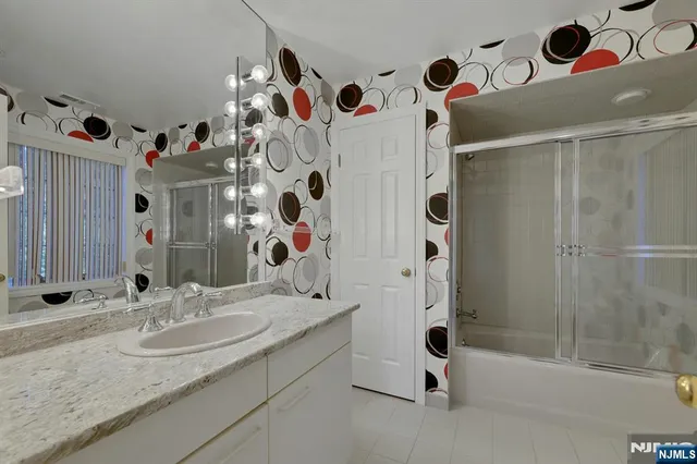 a bathroom with a sink vanity mirror and shower