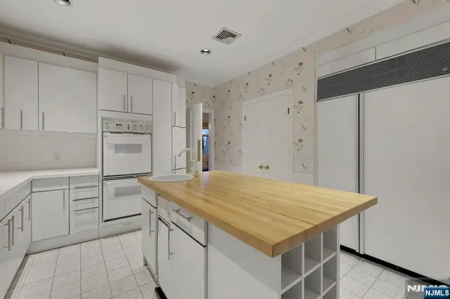 a kitchen with a stove a refrigerator and white cabinets