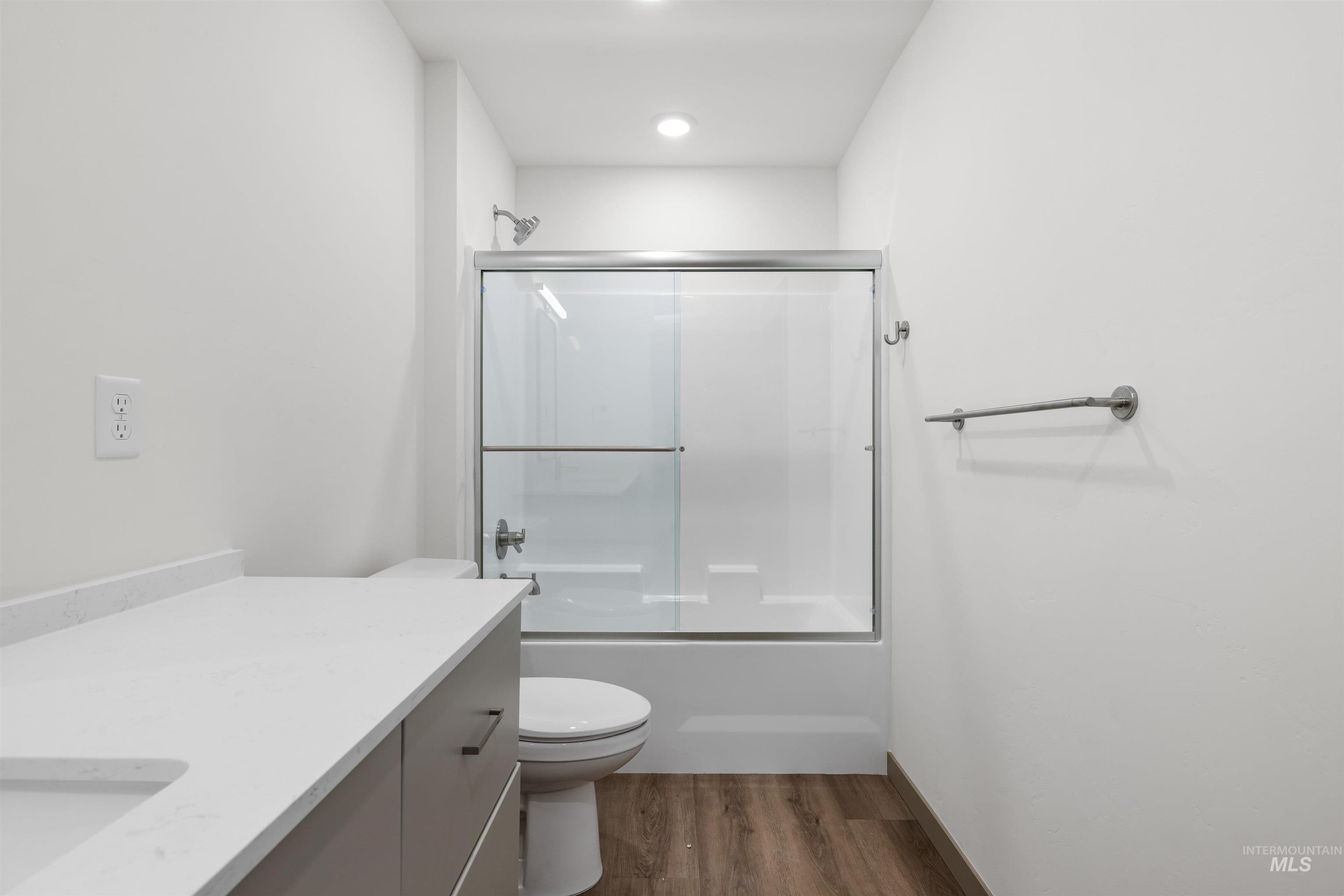 2010 Wimbledon Court Hailey, ID 83333 - Photo 21 of 46 Bathroom featuring bath / shower combo with glass door, vanity, and dark wood-style flooring