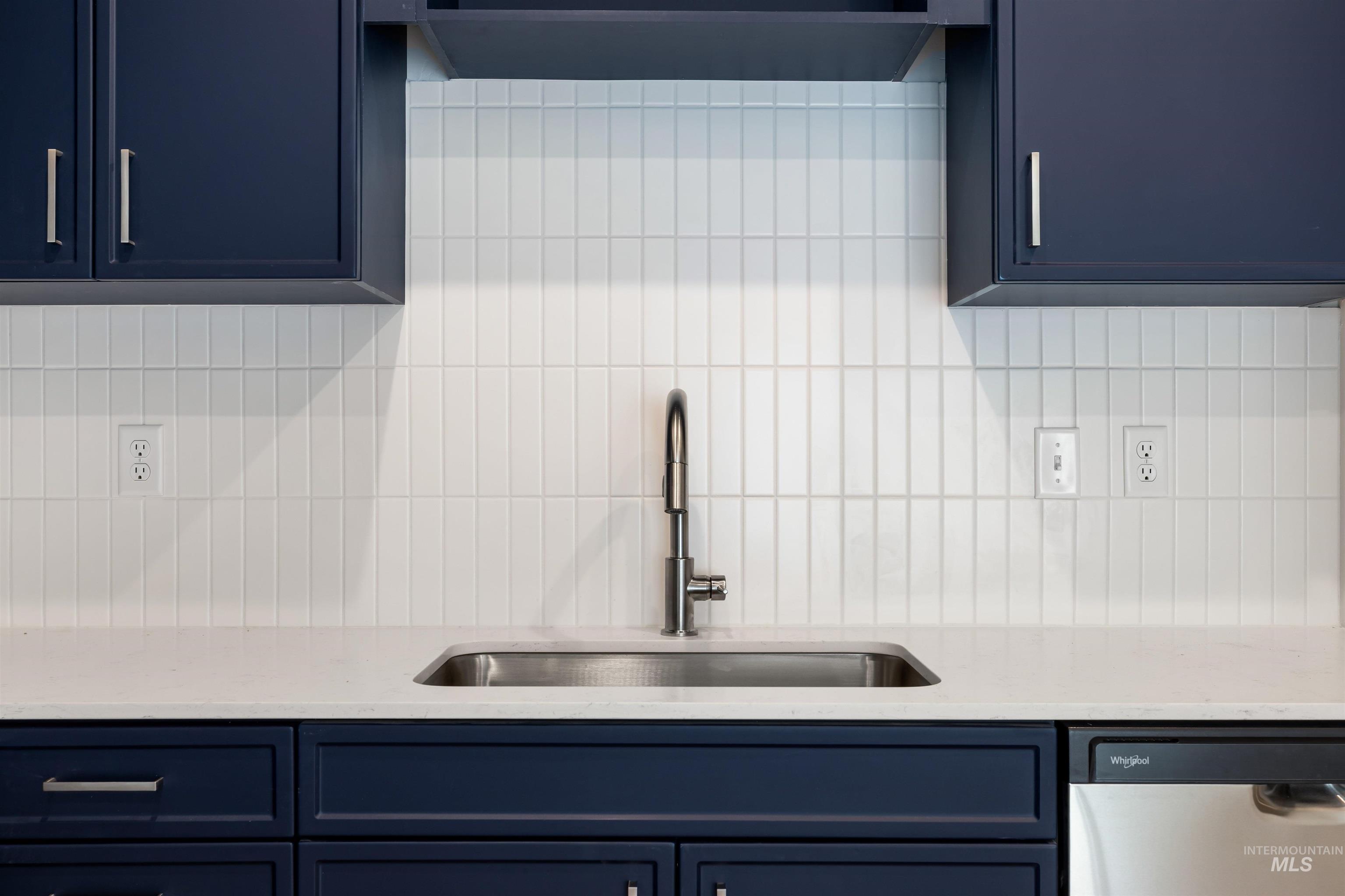 2010 Wimbledon Court Hailey, ID 83333 - Photo 8 of 46 Kitchen with blue cabinets, decorative backsplash, dishwasher, and light stone counters