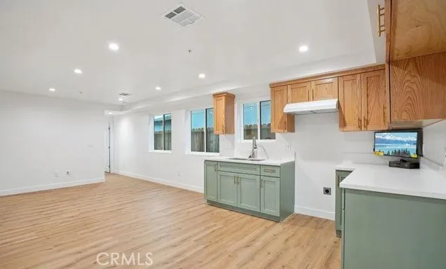 a kitchen with a sink dishwasher a stove and a refrigerator with wooden floor