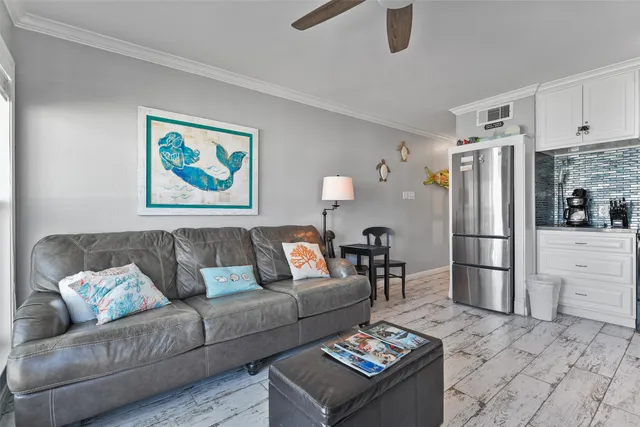 a living room with furniture and a refrigerator