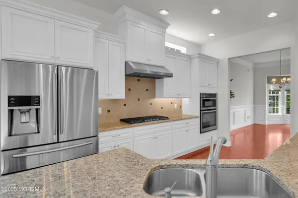 a kitchen with stainless steel appliances granite countertop a sink refrigerator and cabinets