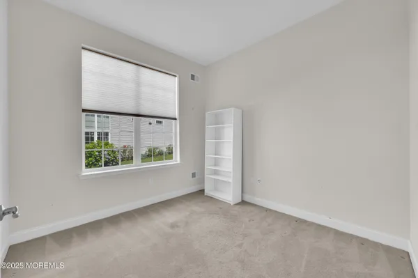 an empty room with windows and closet