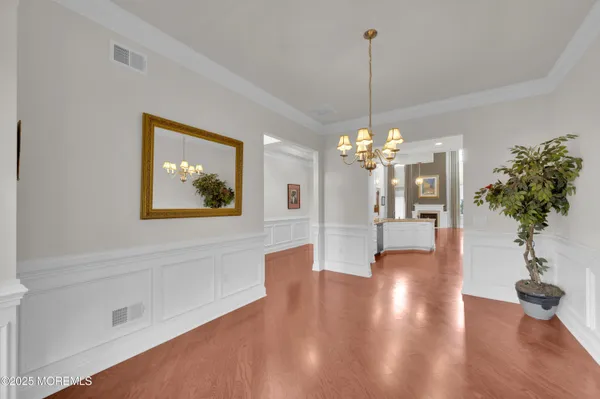 a view of a room with chandelier and wooden floor