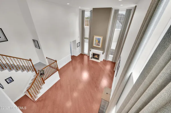 a view of a hallway with wooden floor and stairs