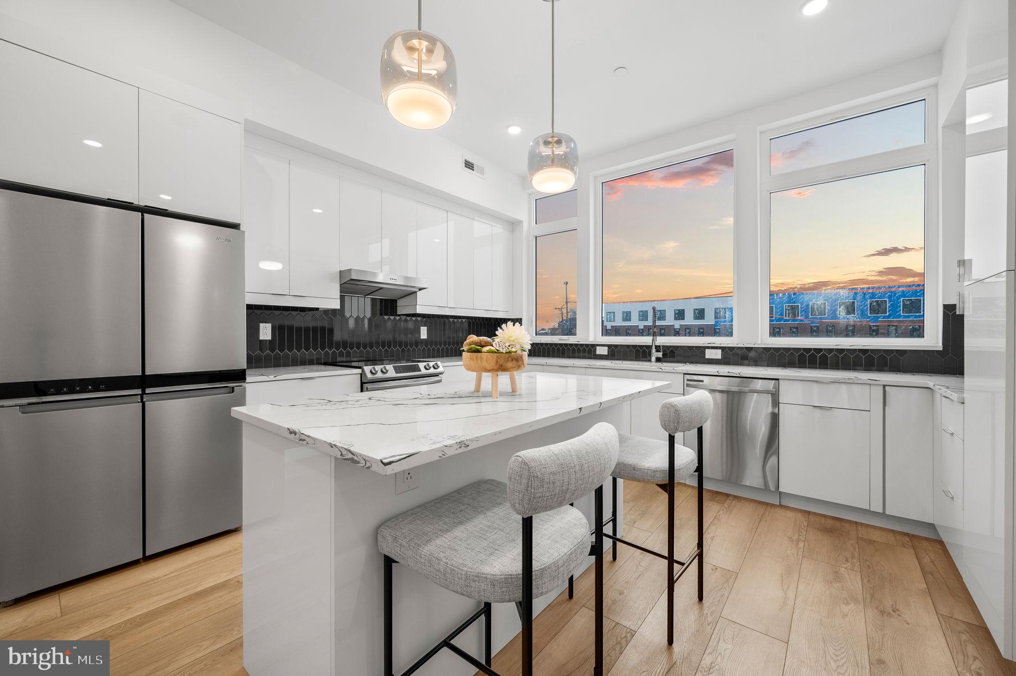 a kitchen with stainless steel appliances granite countertop a stove a refrigerator a oven a sink with a dining table and chairs