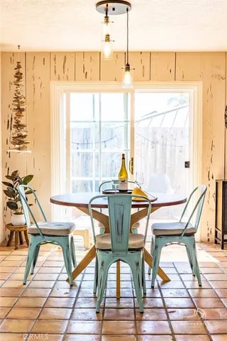 a dining room with wooden floor and glass windows