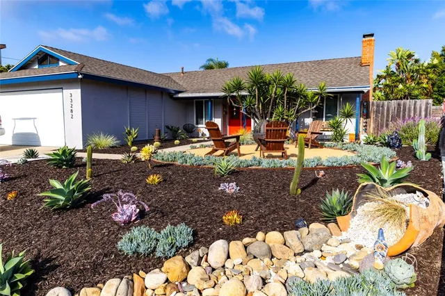 a view of a house with backyard and sitting area