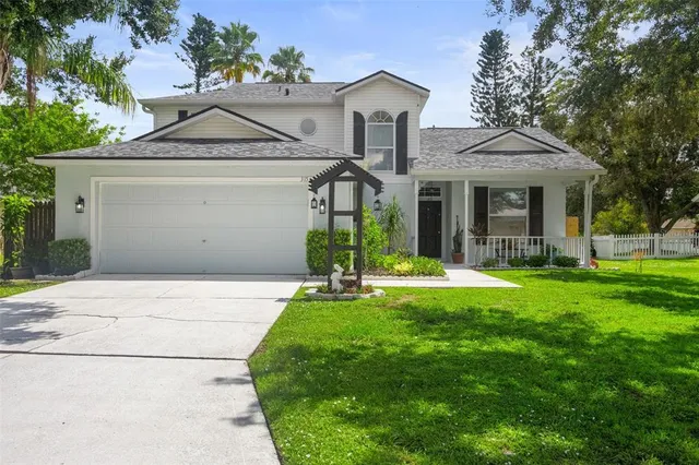 a front view of a house with a yard and potted plants