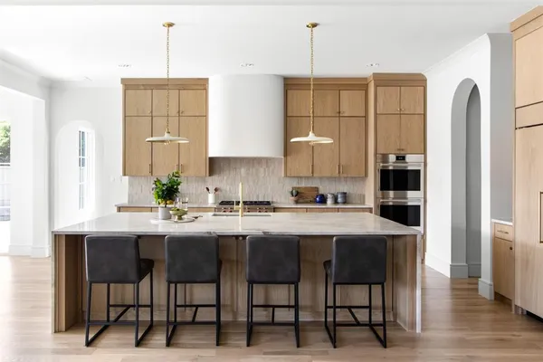 a kitchen with stainless steel appliances kitchen island granite countertop a table chairs and a refrigerator