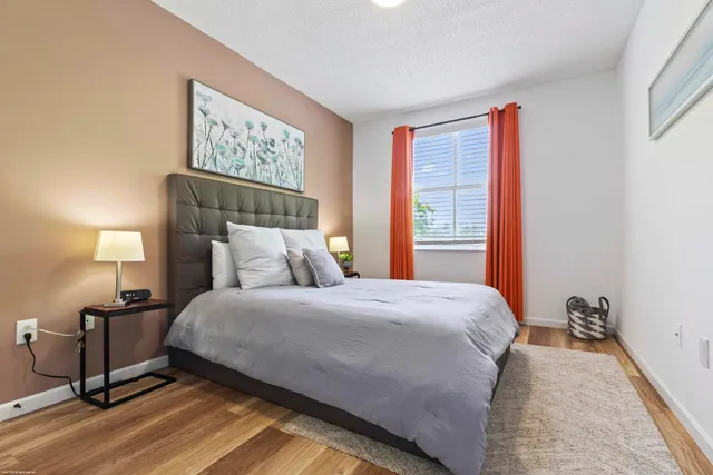 a bedroom with a bed and wooden floor
