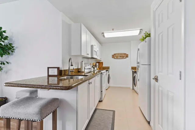 a kitchen with stainless steel appliances granite countertop a sink and a refrigerator