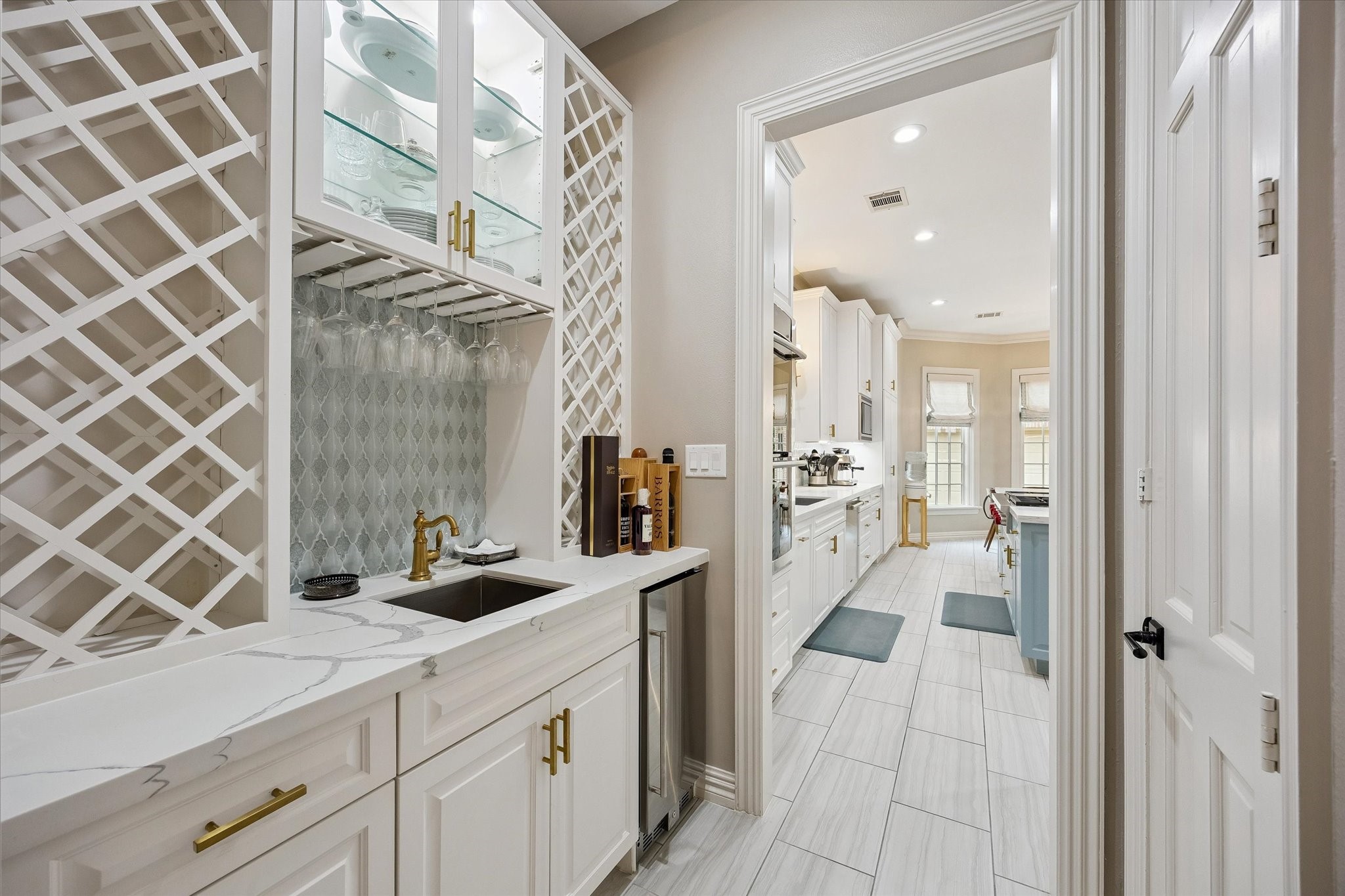 6358 Auden Street Houston, TX 77005 - Photo 9 of 50 Butler's Pantry with built-in wine rack, a beverage fridge, and a sink;all enhanced with the beautiful Quartz countertop and decorative tile backsplash.