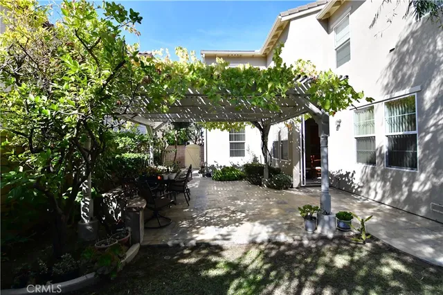 a tree lined with flowers in front of a house