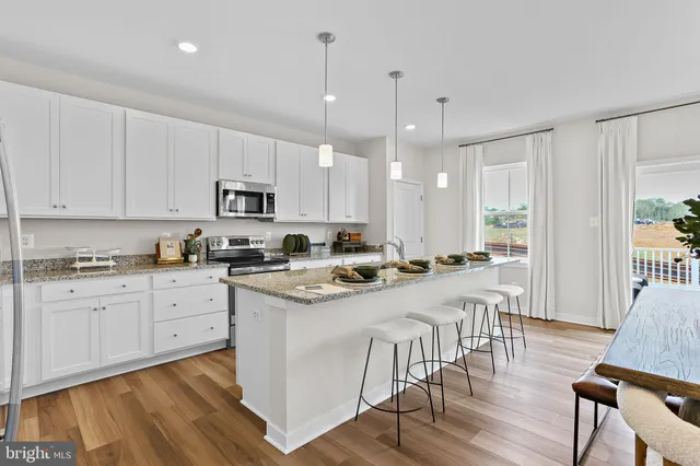 a kitchen with white cabinets and chairs