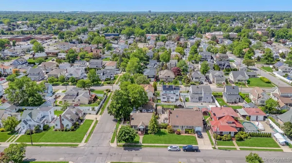an aerial view of residential houses with outdoor space and street view