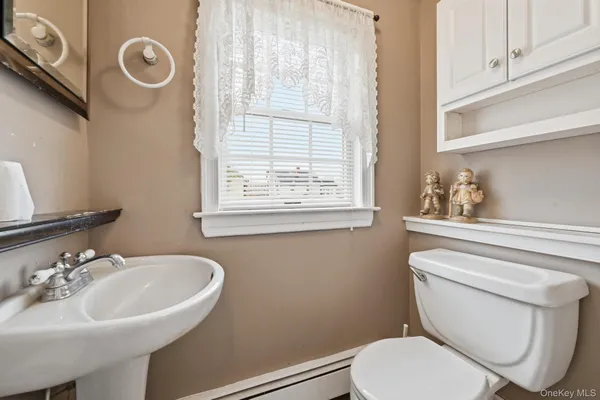 a bathroom with a toilet a sink and a window