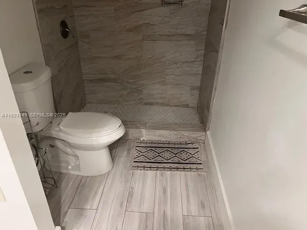 a bathroom with a toilet and a shower