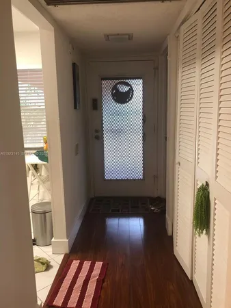 a view of a hallway with wooden floor and a window