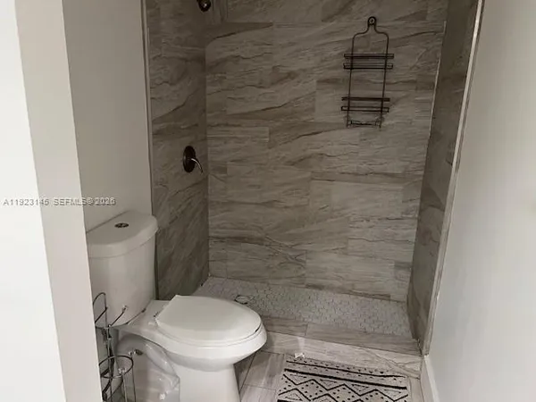 a bathroom with a toilet and a shower