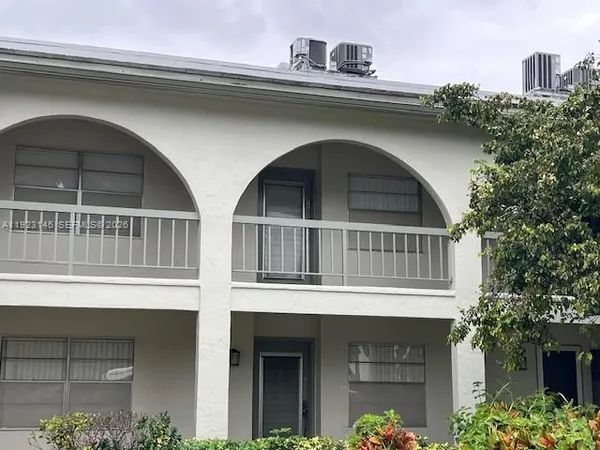 a front view of a house with plants