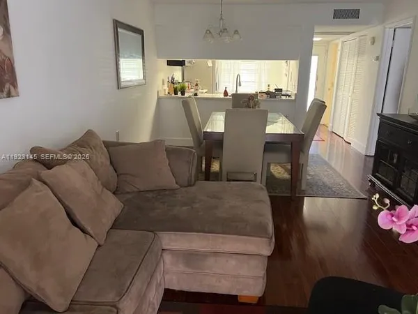 a living room with furniture a flat screen tv and a window