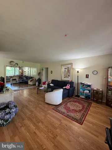 a kitchen with stainless steel appliances wooden floor and a refrigerator