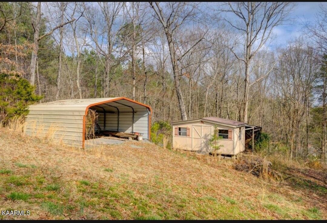 2122 Northwest Old River Road Charleston, TN 37310 - Photo 23 of 28 a backyard of a house with large trees and outdoor seating