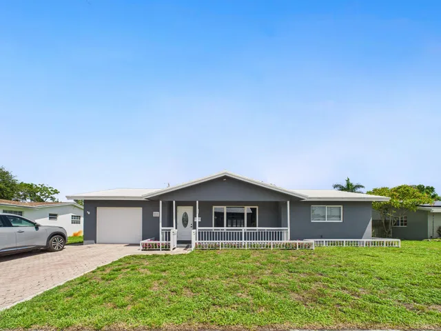 a front view of a house with a garden and yard