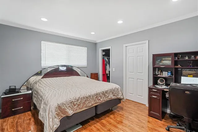 a bedroom with a bed and wooden floor