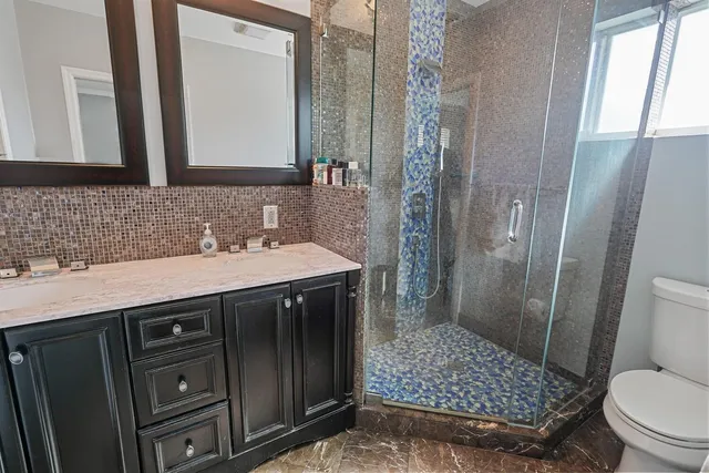 a bathroom with a sink a toilet and shower