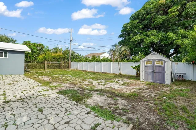 a view of a yard with wooden fence