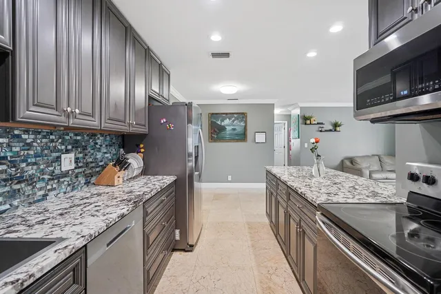 a kitchen with stainless steel appliances granite countertop a sink stove and cabinets