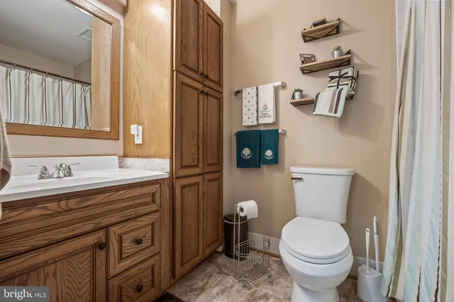 a bathroom with a toilet a sink and mirror