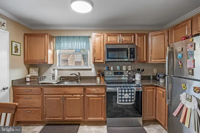 a kitchen with stainless steel appliances granite countertop a stove a sink dishwasher a refrigerator and a microwave