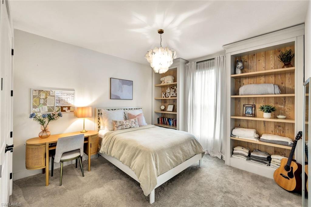 3700 11th Avenue Southwest Naples, FL 34117 - Photo 17 of 50 a bedroom with a bed a table and a chandelier