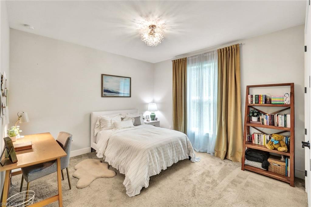 3700 11th Avenue Southwest Naples, FL 34117 - Photo 19 of 50 a bedroom with a bed and a chandelier