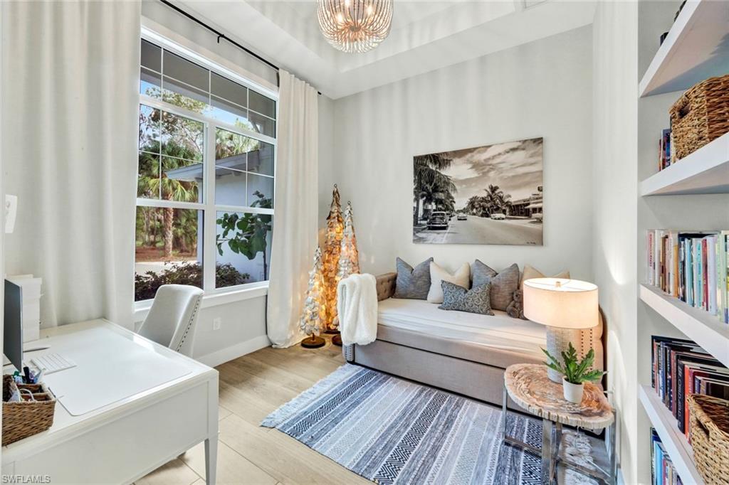 3700 11th Avenue Southwest Naples, FL 34117 - Photo 21 of 50 a living room with furniture and a book shelf