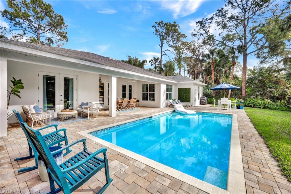 3700 11th Avenue Southwest Naples, FL 34117 - Photo 27 of 50 swimming pool view with a seating space and a garden view