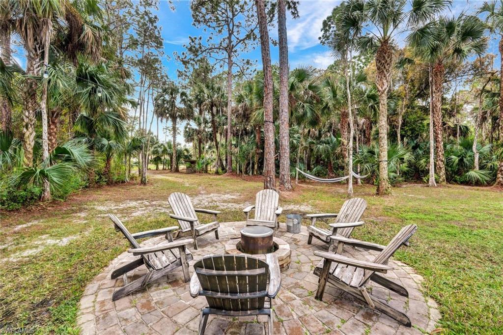3700 11th Avenue Southwest Naples, FL 34117 - Photo 33 of 50 a view of a patio with table and chairs potted plants and large tree
