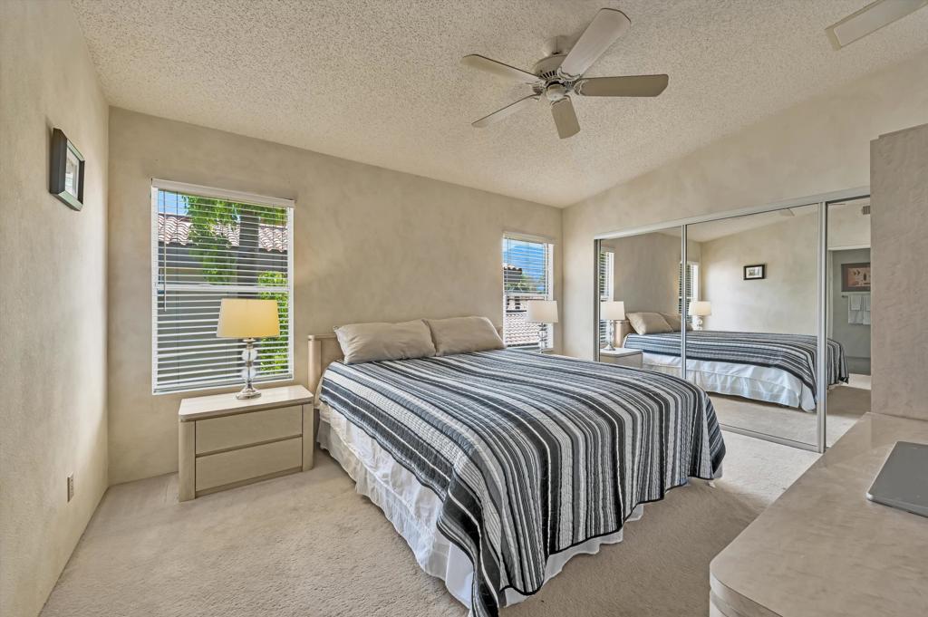 55384 Laurel La Quinta, CA 92253 - Photo 20 of 32 a spacious bedroom with a bed and a chandelier
