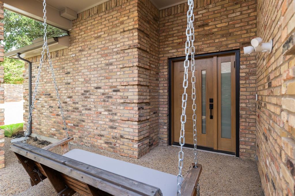 14140 Regency Place Dallas, TX 75254 - Photo 37 of 38 Covered entry with brick veneer facade and exposed aggregate concrete flooring