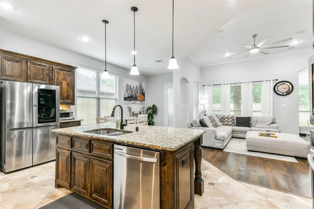 a large kitchen with kitchen island a large counter top space a sink stainless steel appliances and cabinets