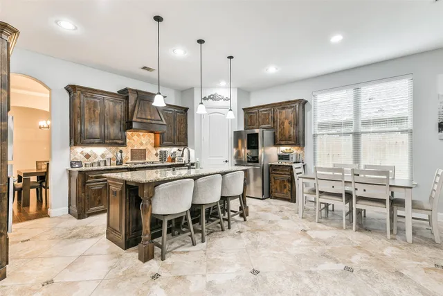 a large kitchen with cabinets table and chairs