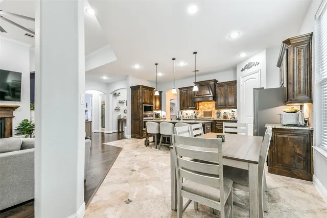 a kitchen with a table chairs refrigerator and microwave