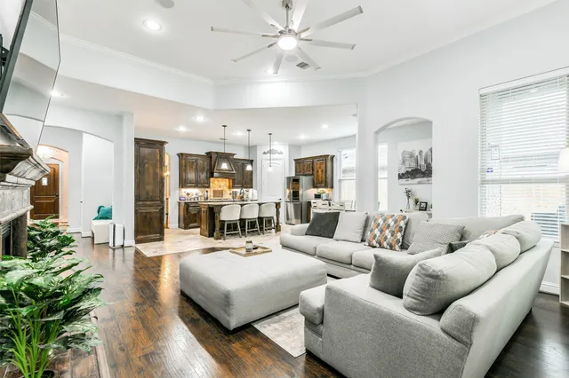 a living room with furniture kitchen view and a large window