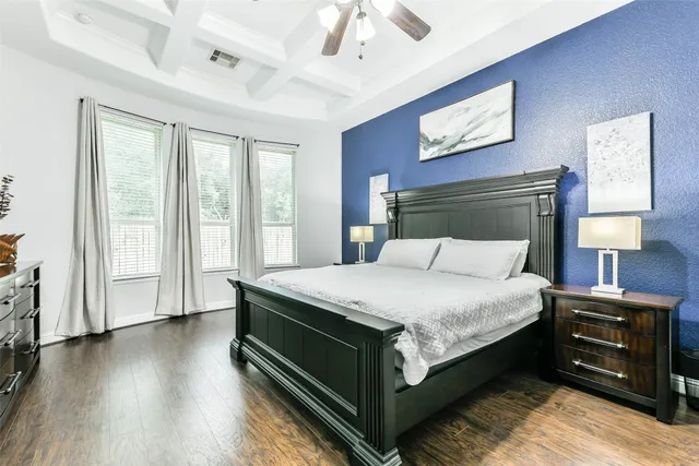 a bed sitting in a spacious bedroom next to a window
