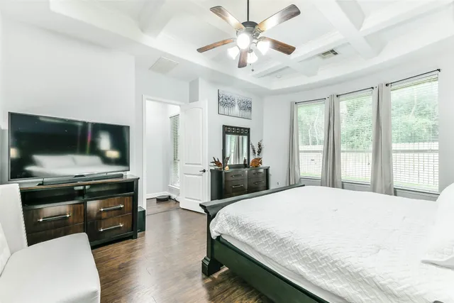 a spacious bedroom with a bed and a flat screen tv