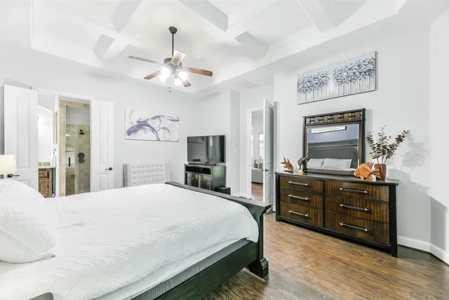 a bedroom with a bed a dresser and flat screen tv